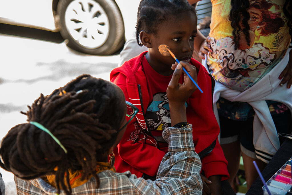 a young person gets their face painted
